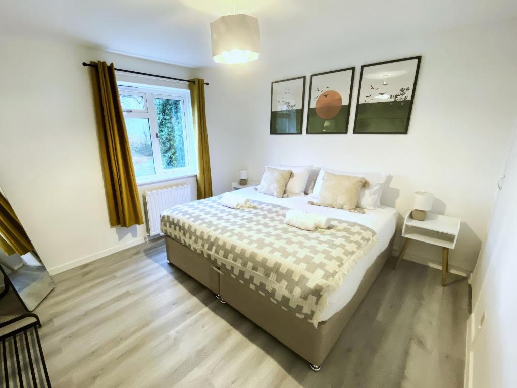 法恩伯勒Home in Farnborough with Free Parking, Wifi & Netflix的一间卧室设有一张床和一个窗口