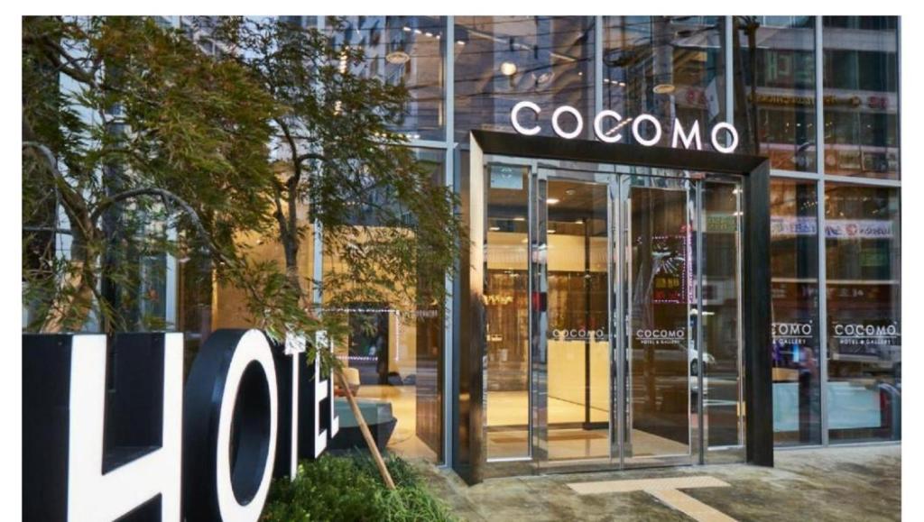 首尔Hotel Cocomo的建筑前有标志的商店