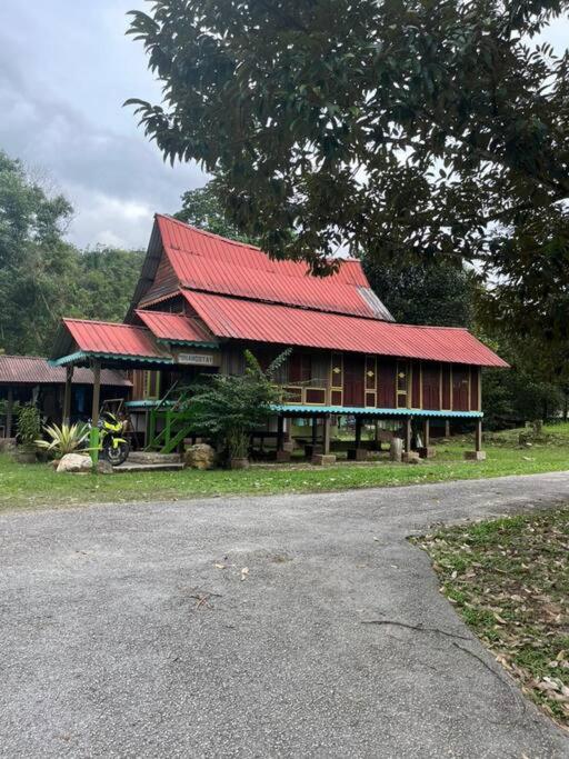 峇冬加里Kampung House (Minang) in Hulu Yam, Batang Kali的路边有红色屋顶的房子