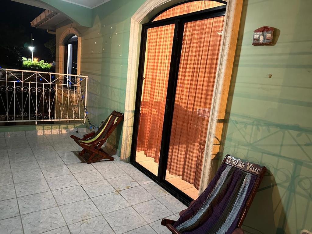 拉塞瓦Vacation Home La Ceiba的门廊上两把椅子,门廊上设有滑动玻璃门