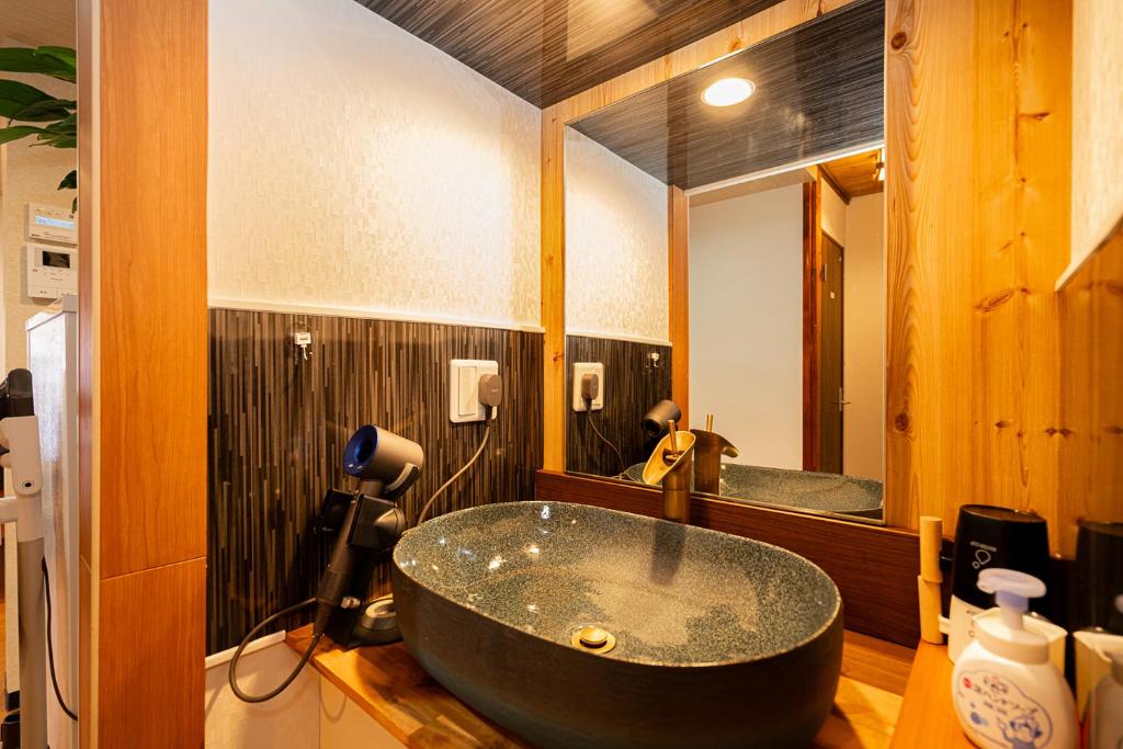 东京一戸建民泊 Tokyo St-ar House 東京星宿的浴室在镜子前设有大型黑色浴缸