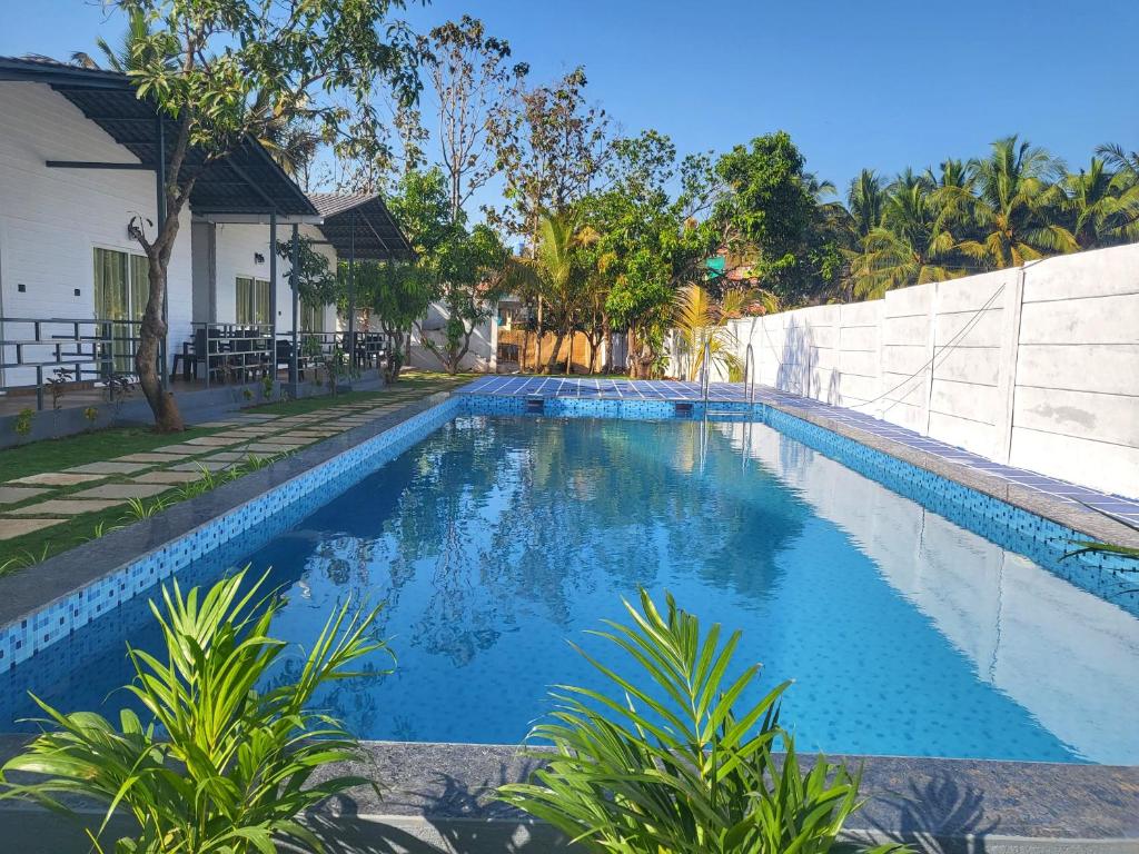 阿姆波尔Rashiva Resort的房屋前的游泳池