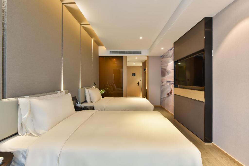 北京北京朝阳门亚朵酒店的酒店客房设有两张床和电视。