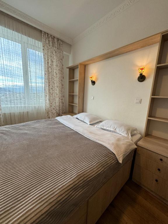 第比利斯Tea's apartment in Tbilisi的一间卧室设有一张大床和一个窗户。