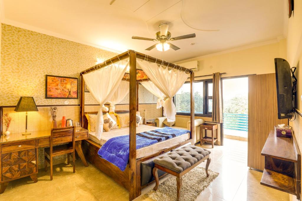 大诺伊达House Of Comfort Greater Noida的一间卧室配有一张天蓬床和一张书桌