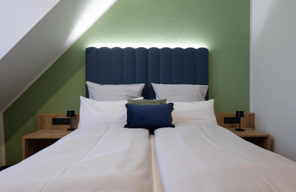 阿尔戈伊地区伊斯尼Reos Hotel Isny的一间卧室配有一张白色大床和蓝色床头板