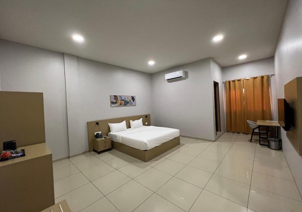 金沙萨Ixoras Hotel Victoire的一间卧室配有一张床和一台电视。