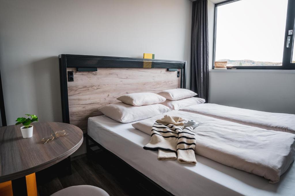 萨尔茨堡harry's XL Hotel的一张带两个枕头的床和一张桌子
