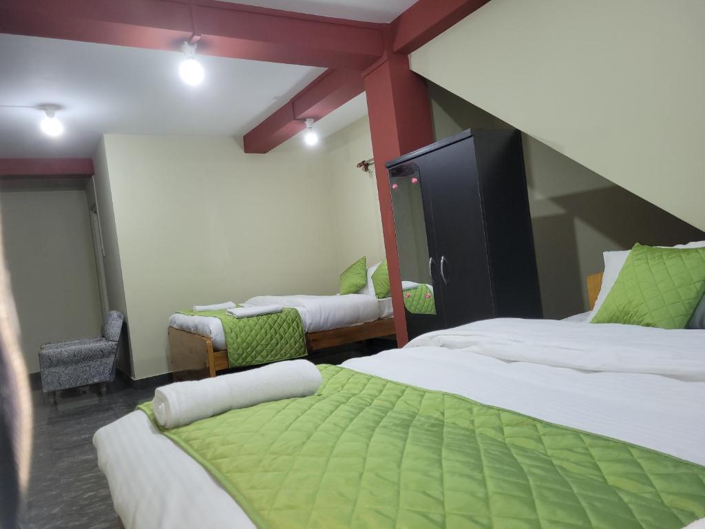 西隆Vati guesthouse的酒店客房,配有两张床和两把椅子