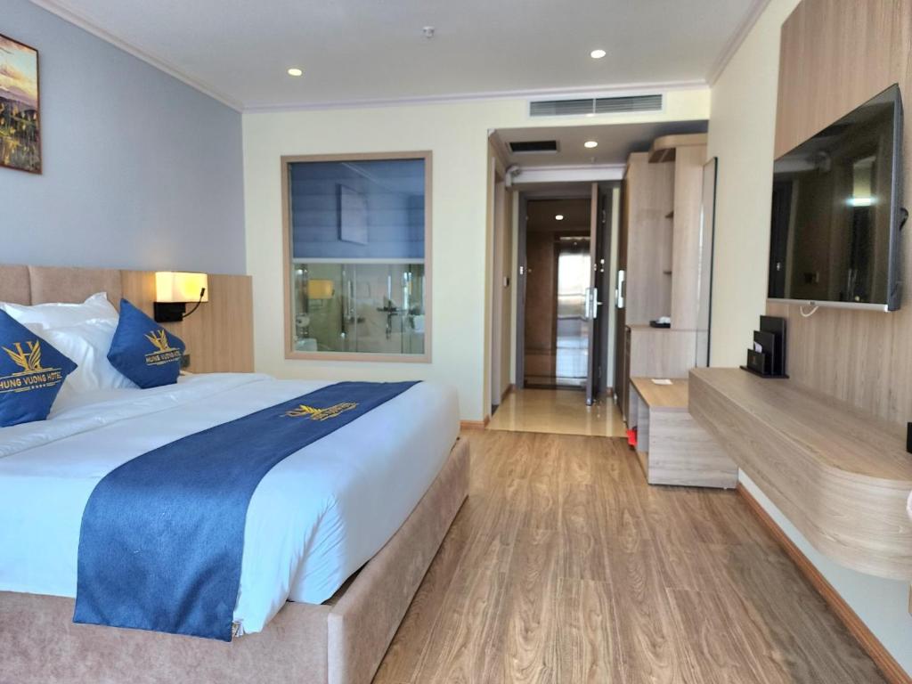 Móng CáiHùng Vương Hotel的酒店客房设有一张大床和一台电视。