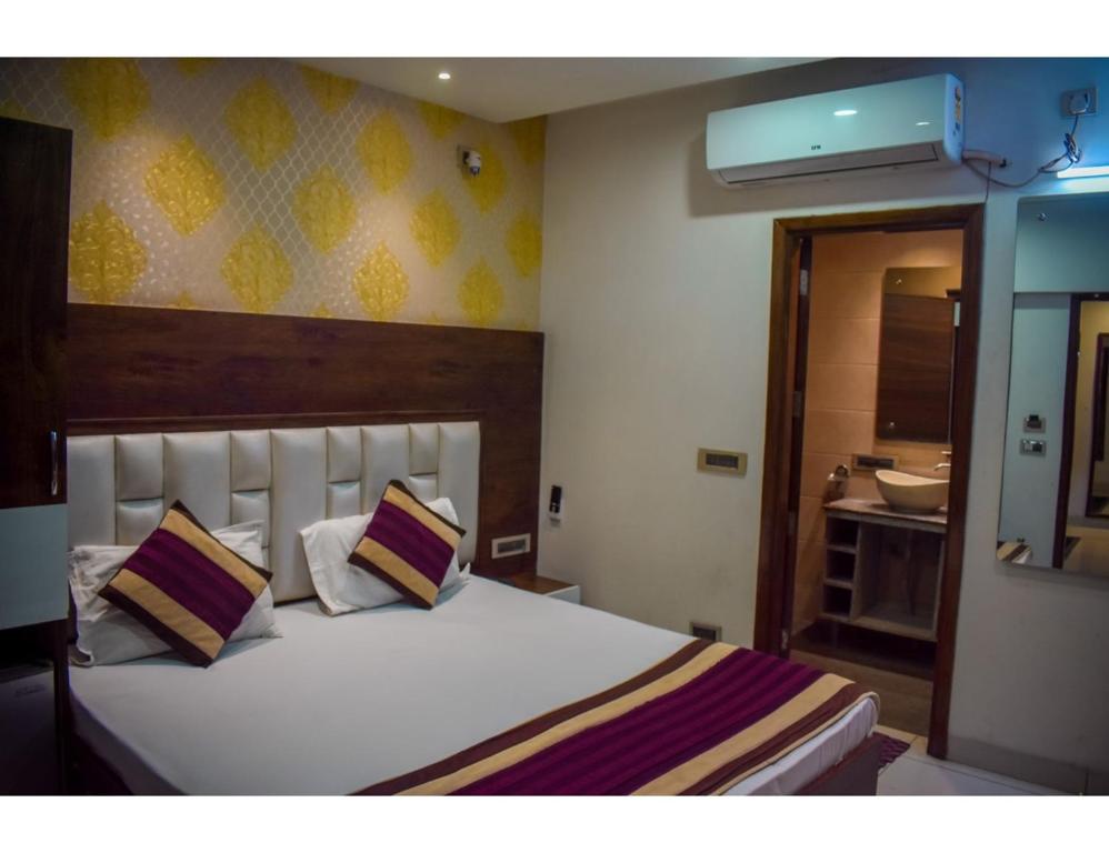 阿姆利则Hotel Sita Niwas Since 1965, Amritsar的卧室配有一张带两个枕头的大白色床