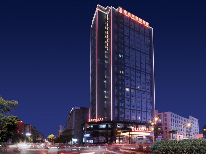 莆田维也纳国际福建莆田明珠酒店的一座高大的建筑,晚上有灯