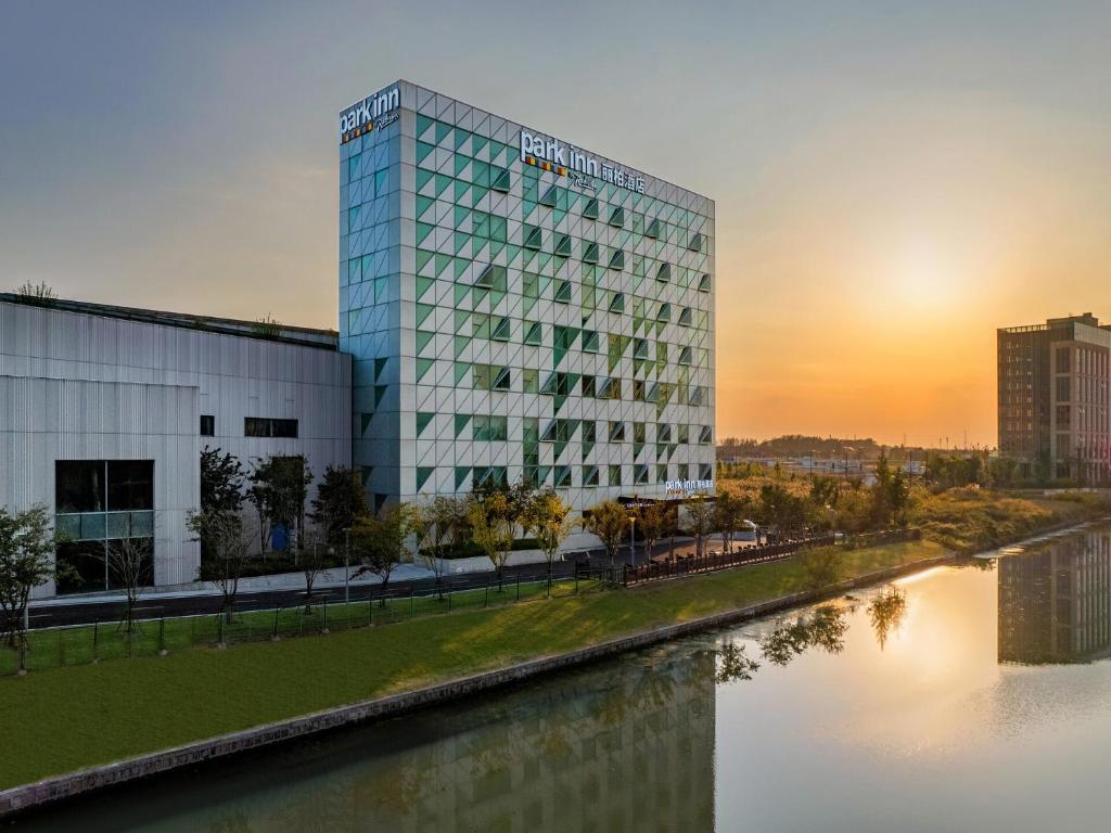 青浦丽柏酒店上海嘉松中路奥特莱斯的河边的建筑,享有日落美景