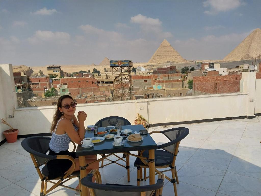 开罗Zoser Pyramids View- Foreiigners only的坐在金字塔前桌边的女人