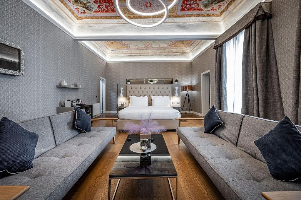 佛罗伦萨Martelli 6 Suite & Apartments的酒店客房设有一张沙发和一张床