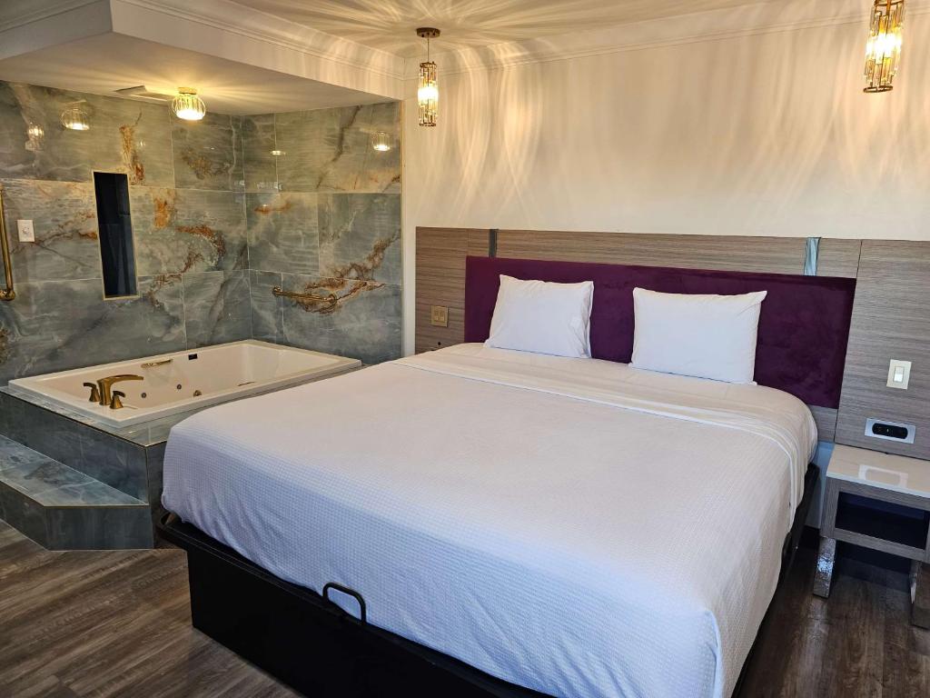 福乐顿市Travelodge Inn & Suites by Wyndham Fullerton的一间卧室配有一张床和浴缸