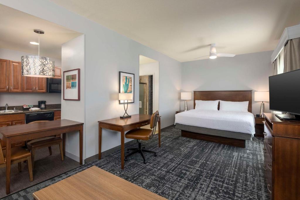 凤凰城凤凰北希尔顿惠庭套房酒店 - 欢乐谷的配有一张床和一张书桌的酒店客房