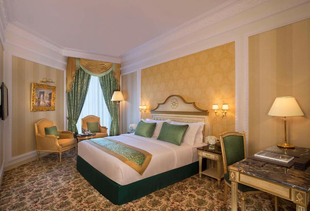 阿布扎比Royal Rose Abu Dhabi, a Curio Collection by Hilton Affiliated Hotel的酒店客房设有一张大床和一张书桌。