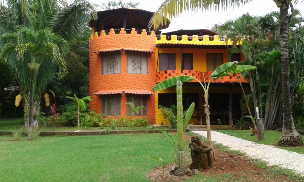 ParaísoEl Castillo Divertido的一座橘色房子,前面有雕像