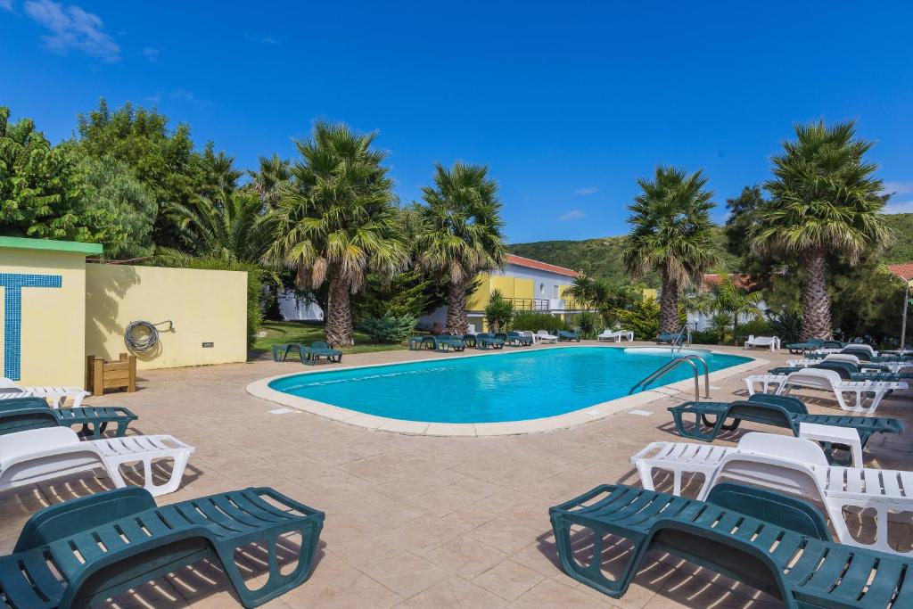 普拉亚达维多利亚Hotel Teresinha的度假村旁的游泳池配有躺椅