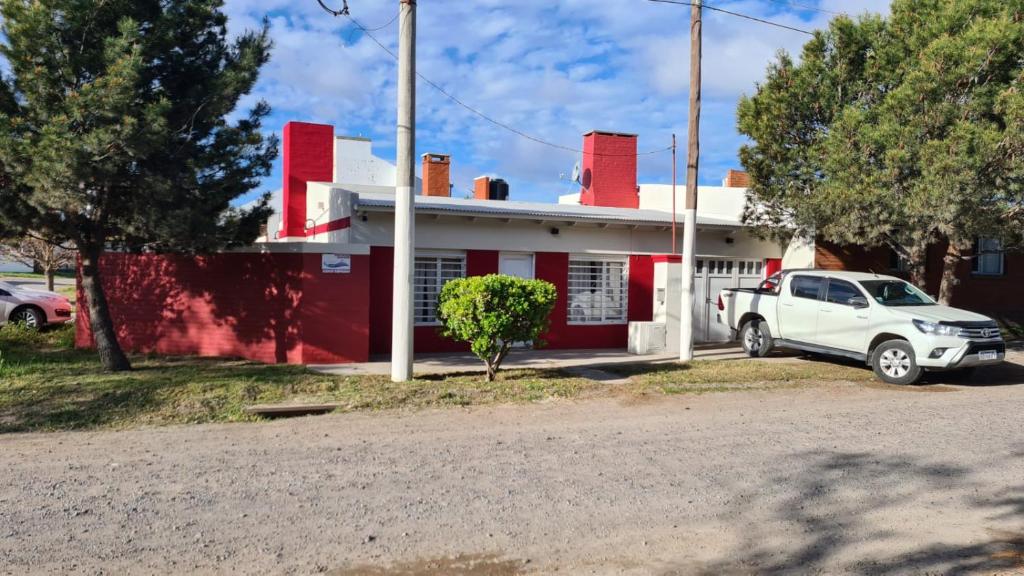 巴尔内阿利奥埃尔康多尔Sonidos del Mar的停在红房子前面的一辆白色卡车