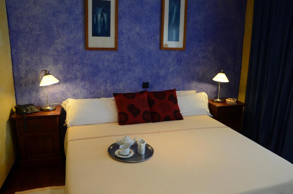 加鲁查蒂卡尔酒店的一间卧室,配有一张带盘子的床