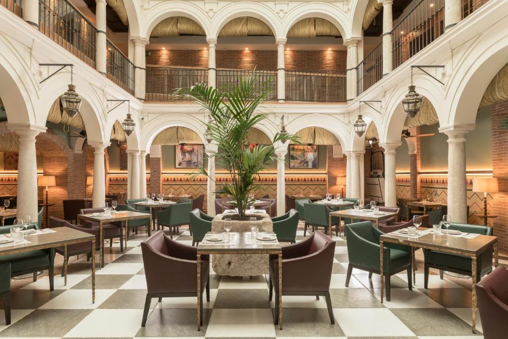 马拉加Palacio Solecio, a Small Luxury Hotel of the World的大楼内带桌椅的餐厅