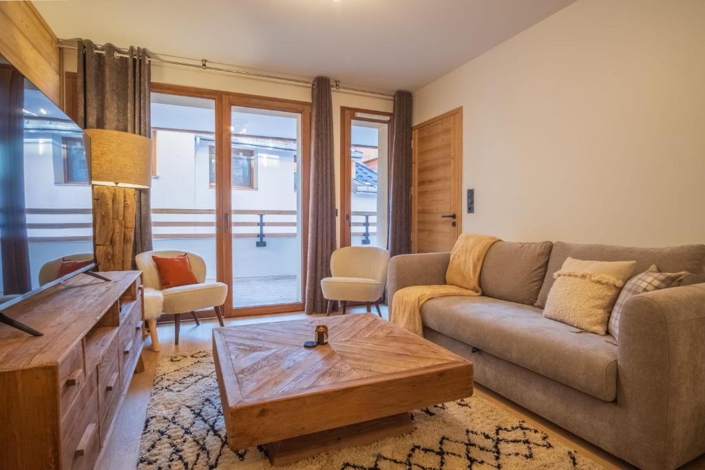 于埃Charming three-room apartment in Huez - Welkeys的带沙发和咖啡桌的客厅