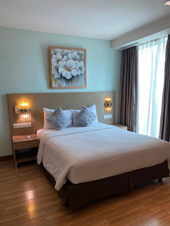 雅加达The H Tower Residence by YLS Stay的一间卧室配有一张带两盏灯的大型白色床。