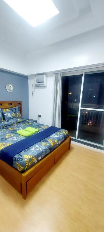 马尼拉2BR, BIG & COZY UNIT 592sqft at TORRE DE MANILA的一间卧室设有一张床和一个大窗户