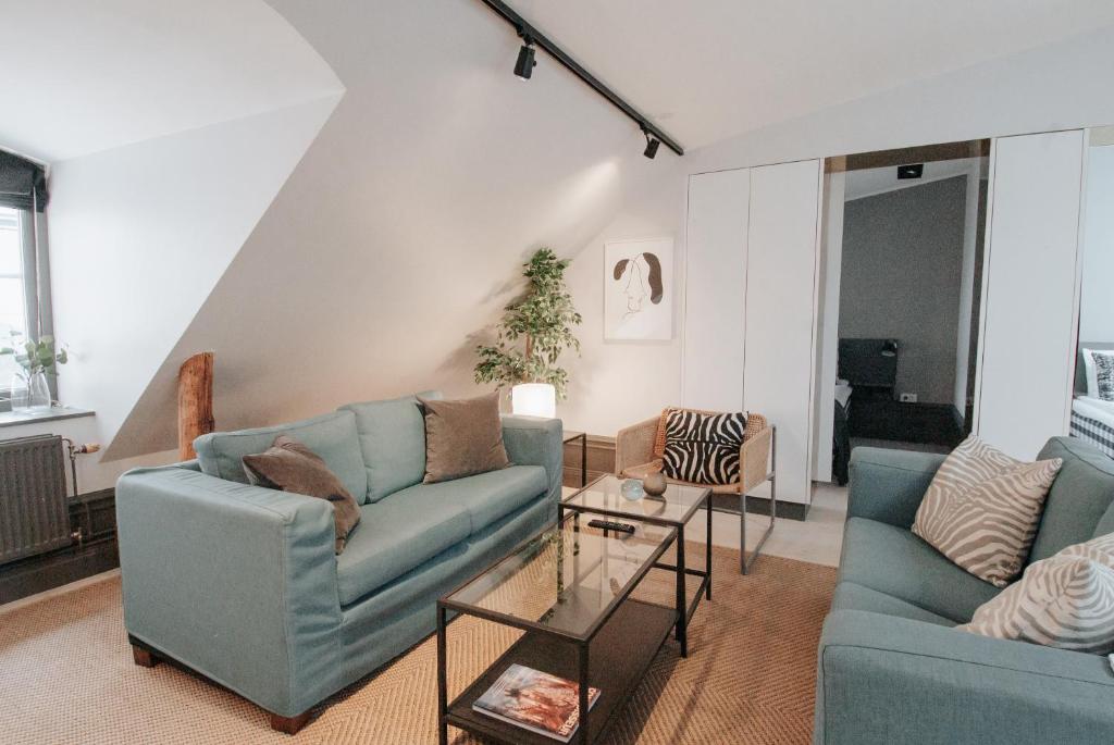 斯德哥尔摩Guldgränd的客厅配有2张蓝色的沙发和1张桌子