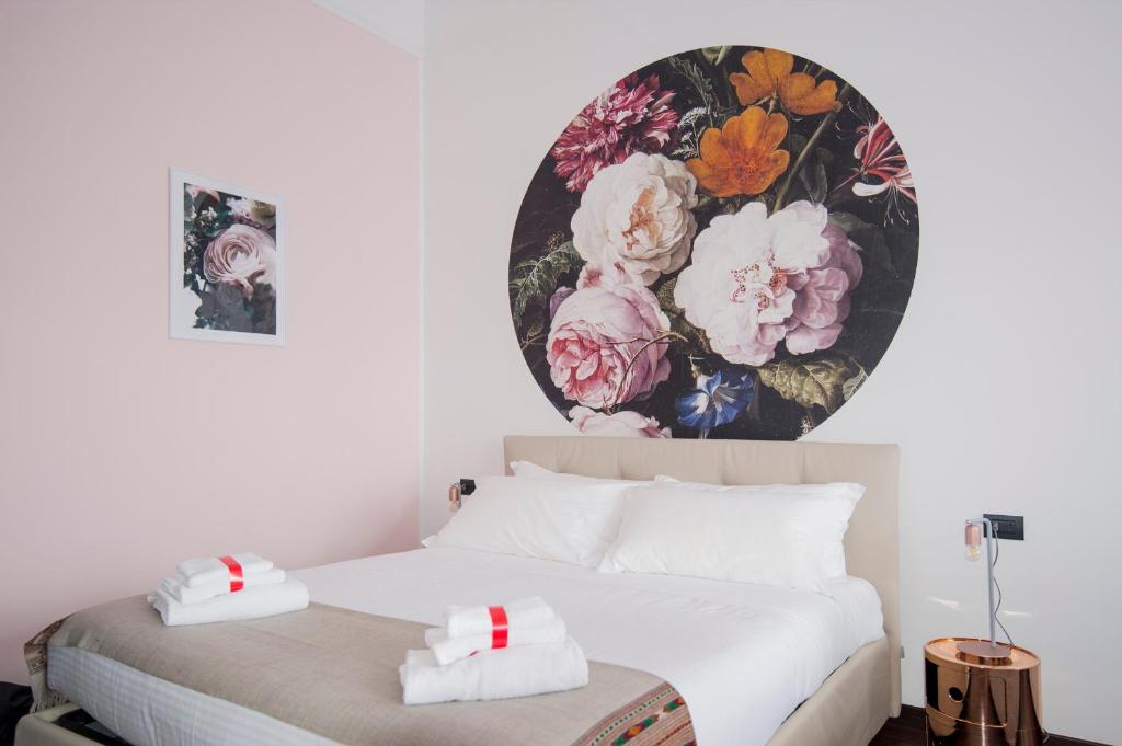 米兰DUOMO VIEW - 2 min from Duomo Amazing location的卧室配有一张挂有花卉画的床铺。