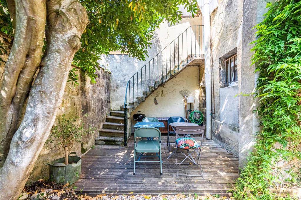 波尔多Beautiful apartment in Bordeaux with garden的门廊上设有桌椅和楼梯