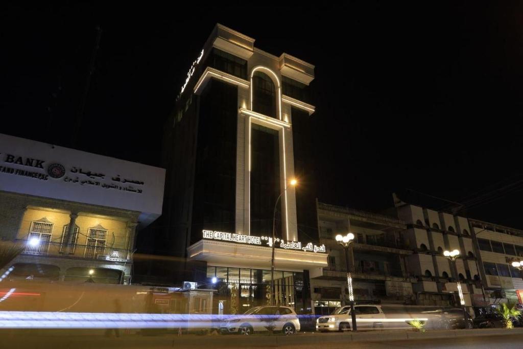 巴格达The Capital Heart Hotel的一座大建筑,在晚上有高塔