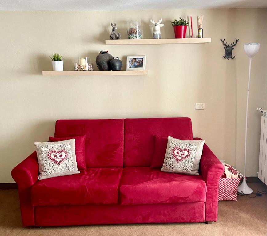 BreuilAlpine Studio with Garage的客厅里配有红色沙发,提供两个枕头