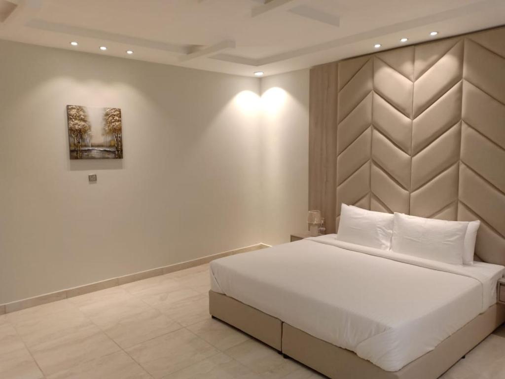塔伊夫Dorm Story For Hotel Apartment的卧室配有一张白色大床和一堵墙