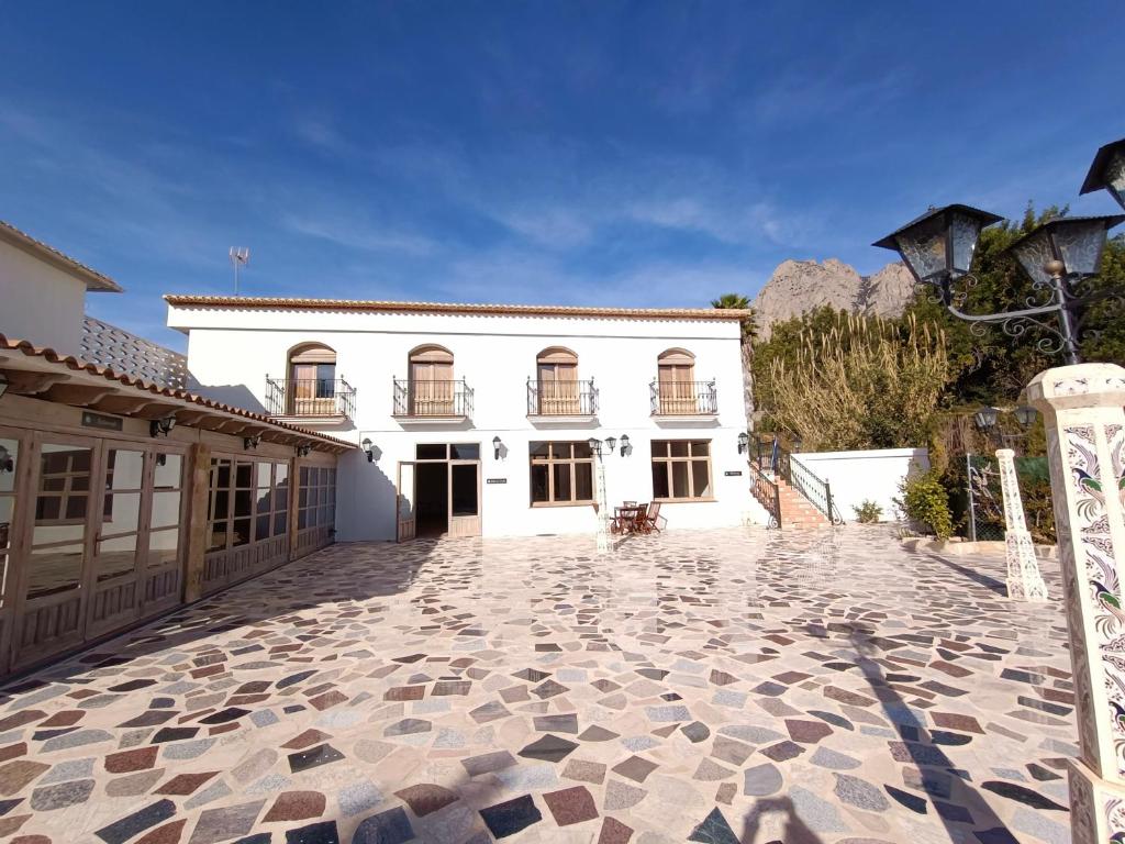 菲内斯特拉特Villa Morena的一座白色的大建筑,设有石头庭院