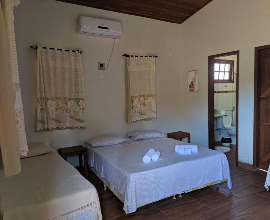 Rio NovoHOTEL FAZENDA CANARIO DA TERRA的一间卧室设有两张床和窗户。