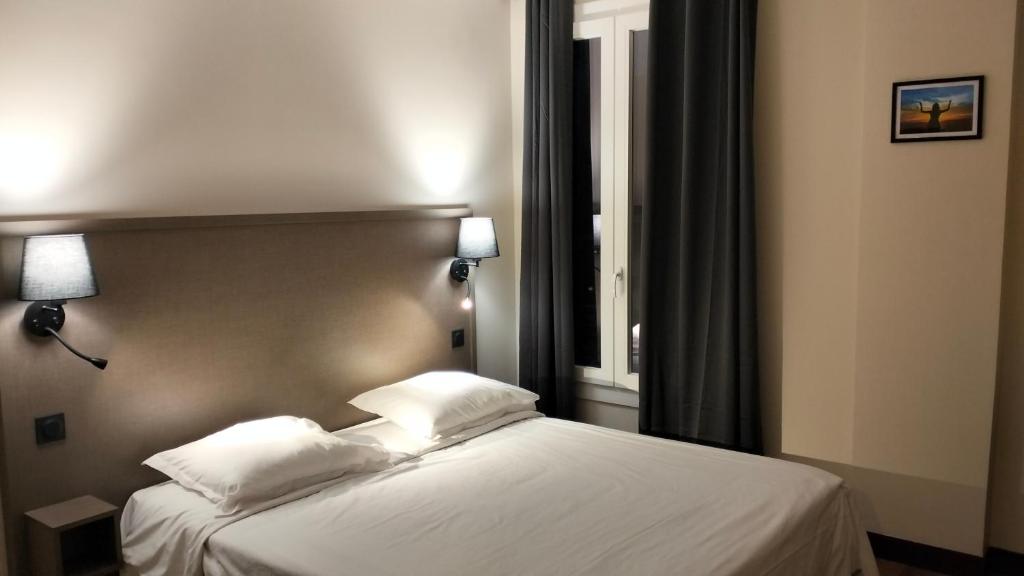 蒙特勒伊HÔTEL ROYAL MONTREUIL的一间卧室配有带白色床单和枕头的床。