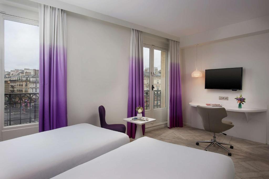 巴黎NH Paris Gare de l'Est的配有一张床和一张书桌的酒店客房