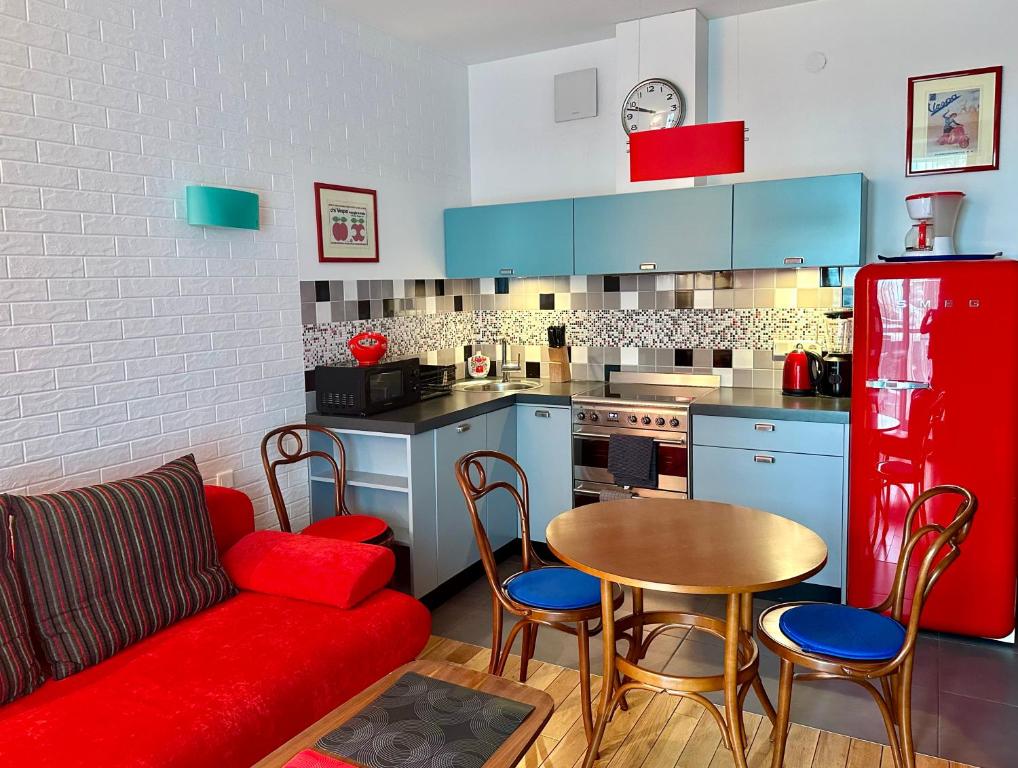 华沙Project Comfort Leszczyńska 4/33 Warszawa的一间带红色沙发的客厅和一间厨房