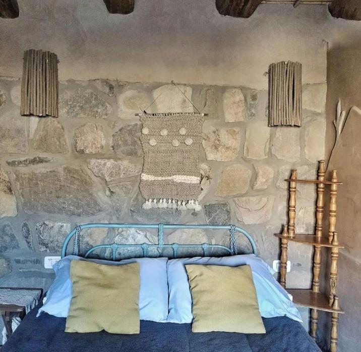 麦马拉El Cerrito的一间卧室设有石墙和床