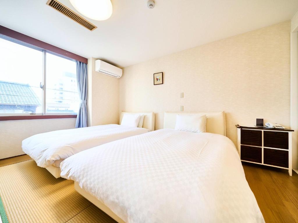 大垣Okasan Hotel - Vacation STAY 45146v的带大窗户的客房内的两张床