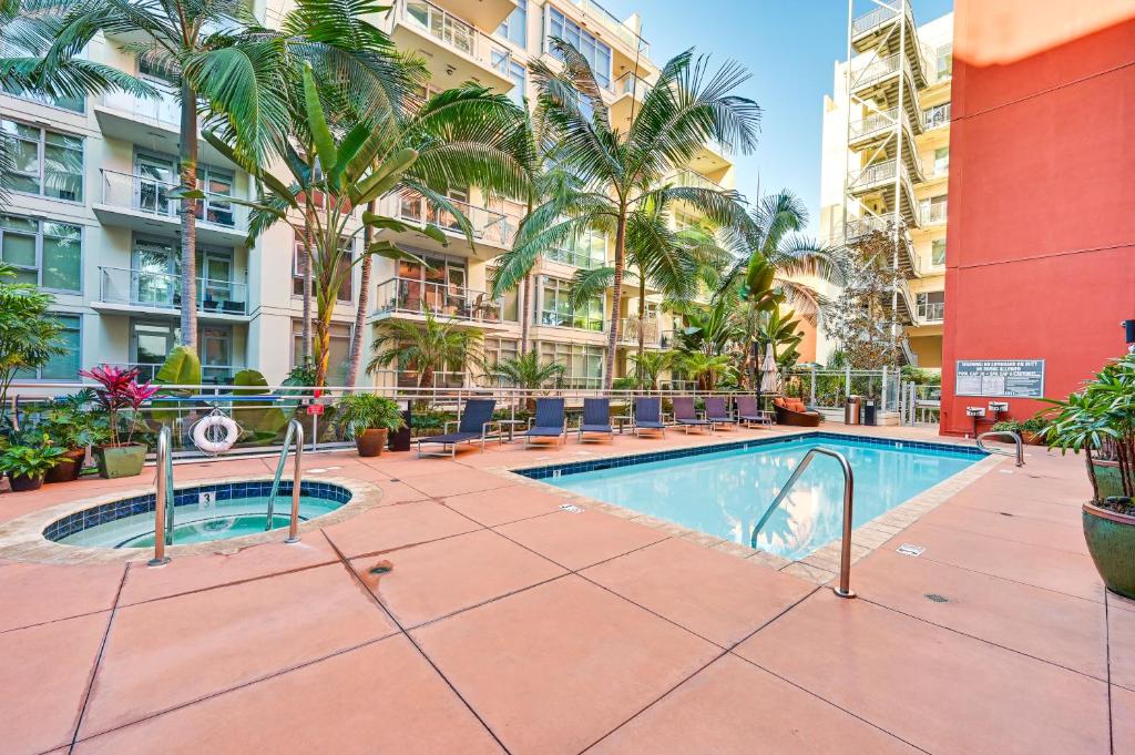 圣地亚哥High-End San Diego Condo with Pool and Rooftop Access的棕榈树公寓大楼庭院内的游泳池