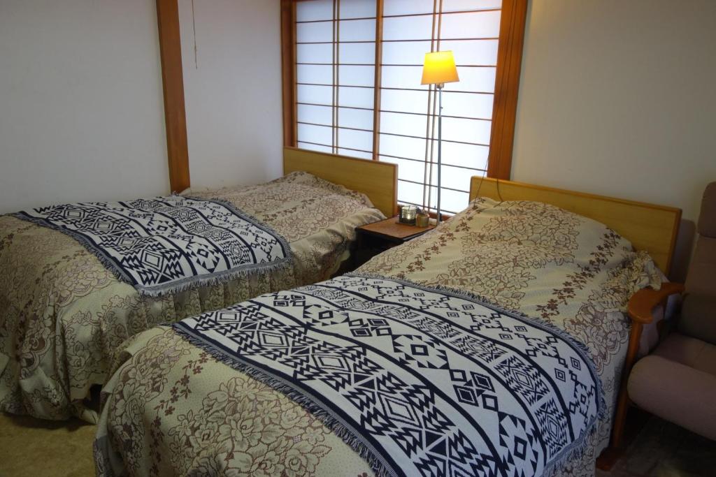 佐渡市Natural Mind Tour - Vacation STAY 56703v的一间卧室设有两张床和窗户。