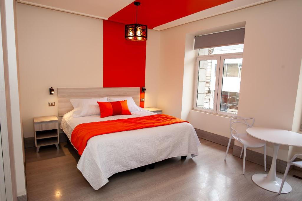 瓦尔帕莱索Casa Esmeralda的一间卧室配有一张红色墙壁的床