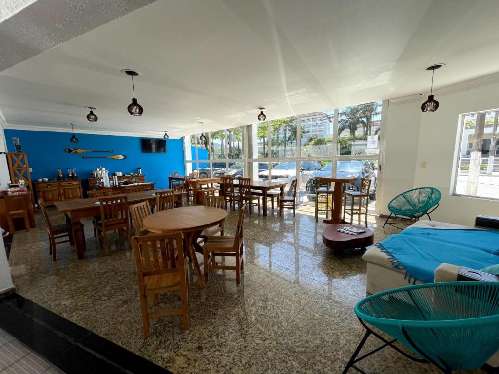 瓜鲁雅Bene Beach - Pousada Guarujá的带桌椅的房间和用餐室