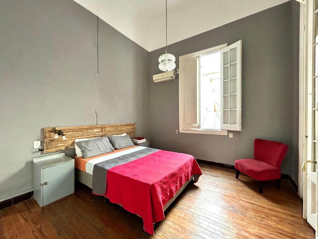 蒙得维的亚Hostel Bohemian House的一间卧室配有一张床和一张红色椅子