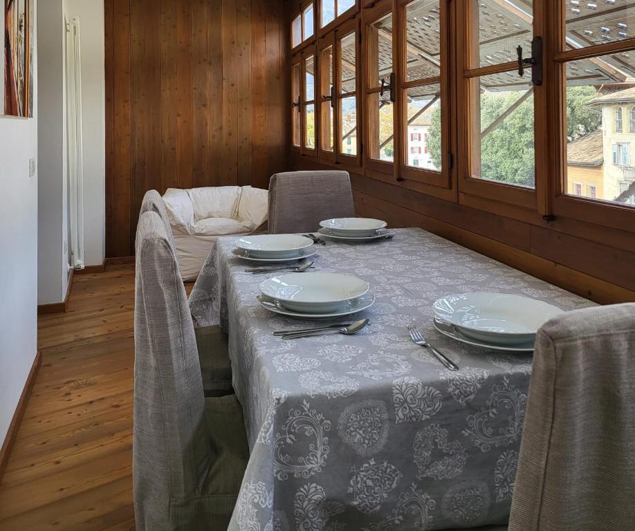 罗韦雷托La Casa dei Turchi的一间带桌椅和盘子的用餐室