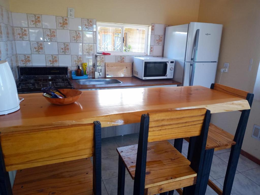 圣卡洛斯-德巴里洛切El Llanqui的厨房配有木桌和冰箱。